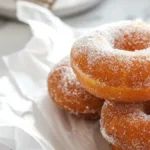 Stack of sugar-coated donuts with Cakey Bites logo on a marble background, visually supporting the article Are Mochi Donuts Gluten Free? A Tasty Guide to Know.